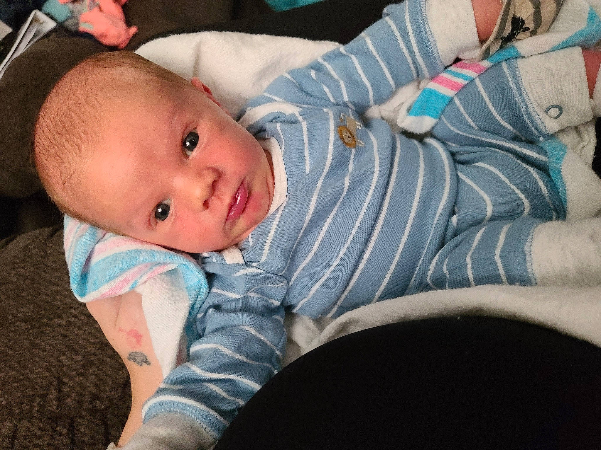 Leyton is registered to the contest to win money with this photo: baby, baby_products, baby_safety, baby_toddler_clothing, cheek, child, comfort, eye, fun, human_body, iris, linens, mammal, mouth, nose, person, sitting, skin, sleeve, toddler