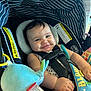 baby, canopy, car_seat, cheeks, child, closeup, comfort, cute, face, happy, indoors, infant, person, playful, plush_toy, seatbelt, smiling, straps, striped, toy