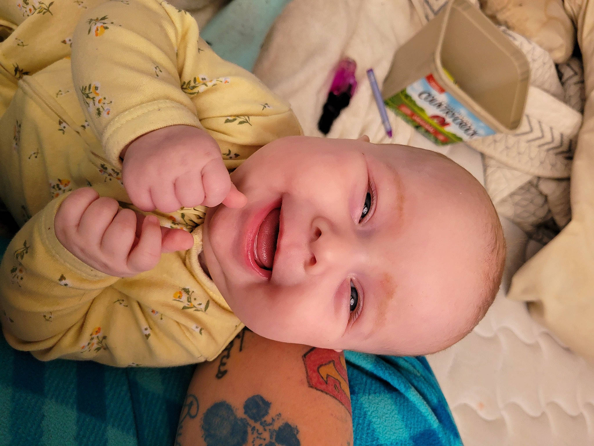 Daenerys is registered to the contest to win money with this photo: baby, baby_toddler_clothing, cheek, child, ear, eyebrow, eyelash, finger, happy, iris, lip, mouth, neck, nose, pattern, person, pink, skin, smile, textile