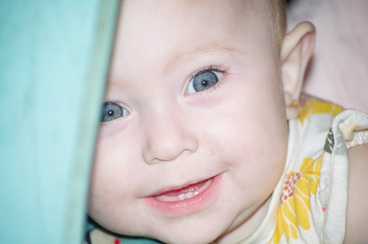 Daenerys is registered to the contest to win money with this photo: baby, baby_toddler_clothing, cheek, child, chin, close_up, ear, eye, eyebrow, eyelash, facial_expression, flash_photography, happy, headwear, iris, joy, lip, mouth, nose, person