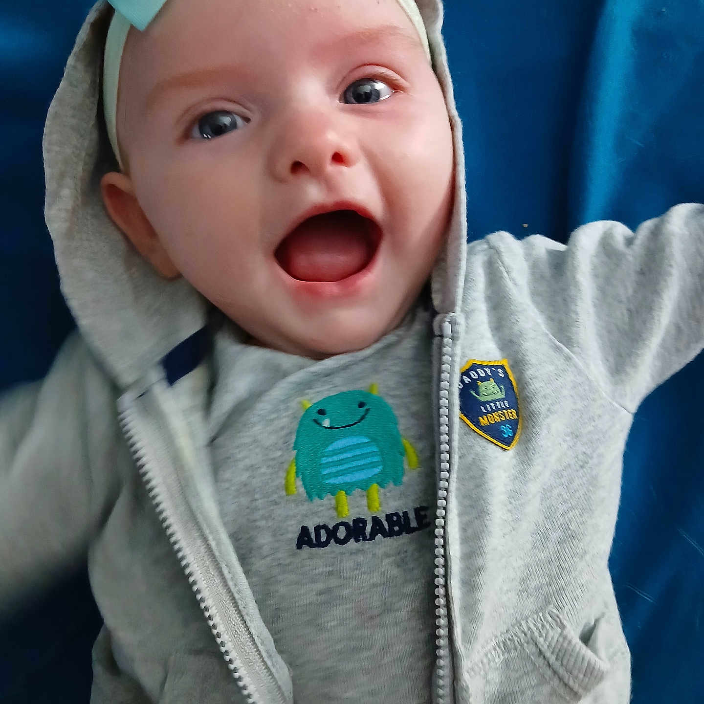 Shoshanna is registered to the contest to win money with this photo: baby, bodypart, bonnet, cap, clothing, coat, face, happy, hat, head, hood, hoodie, jacket, knitwear, mouth, person, photography, portrait, sweater, sweatshirt