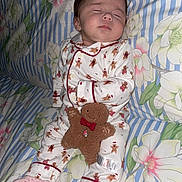 Marykate joined the competition — help win amazing prizes! baby, sleeping, pajamas, gingerbread, plush_toy, bedspread, floral, striped, cute, infant, child, soft_lighting, indoors, cozy, peaceful, pink_socks, toy, smiling_toy, holiday_theme, child_sleeping