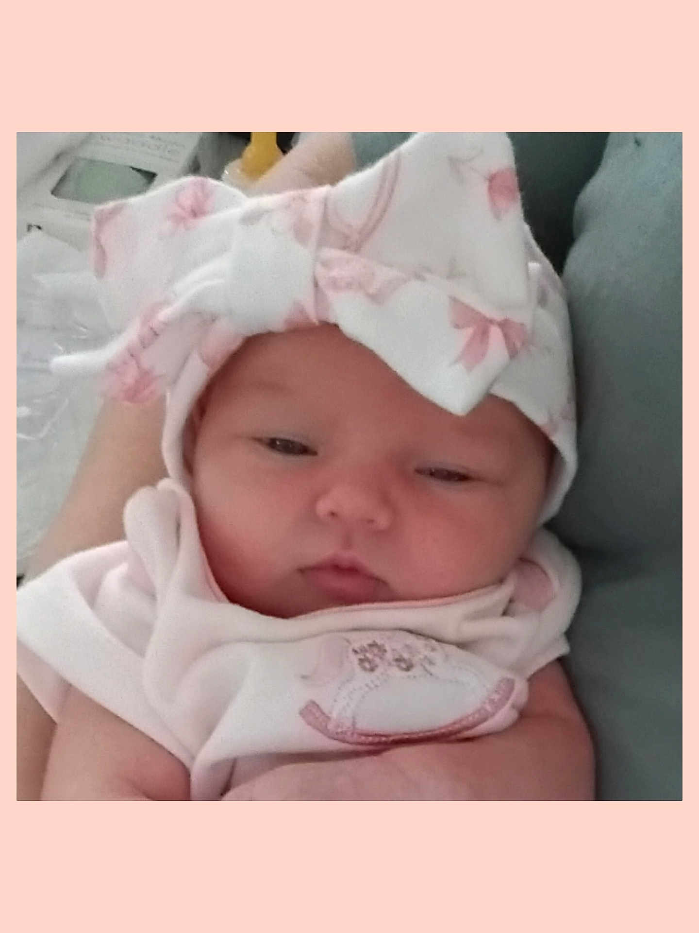 Danica Lynn is registered to the contest to win money with this photo: baby, newborn, infant, hat, bow, pink_clothing, sleepy, chubby_cheeks, portrait, close_up, face, hands, blanket, cozy, lying_down, caregiver_arm, fabric, headwear, adorable, soft_lighting