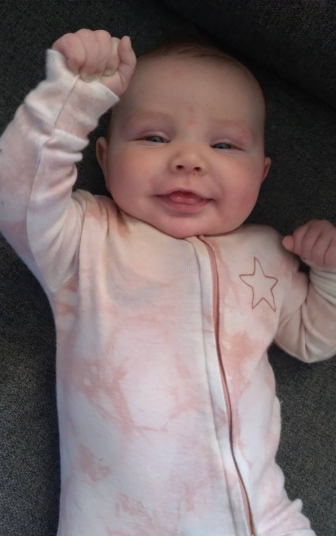 Riverlynn is registered to the contest to win money with this photo: baby, baby_toddler_clothing, cheek, child, eyebrow, face, finger, flash_photography, gesture, hand, happy, iris, lip, person, pink, skin, sleeve, smile, textile, thumb