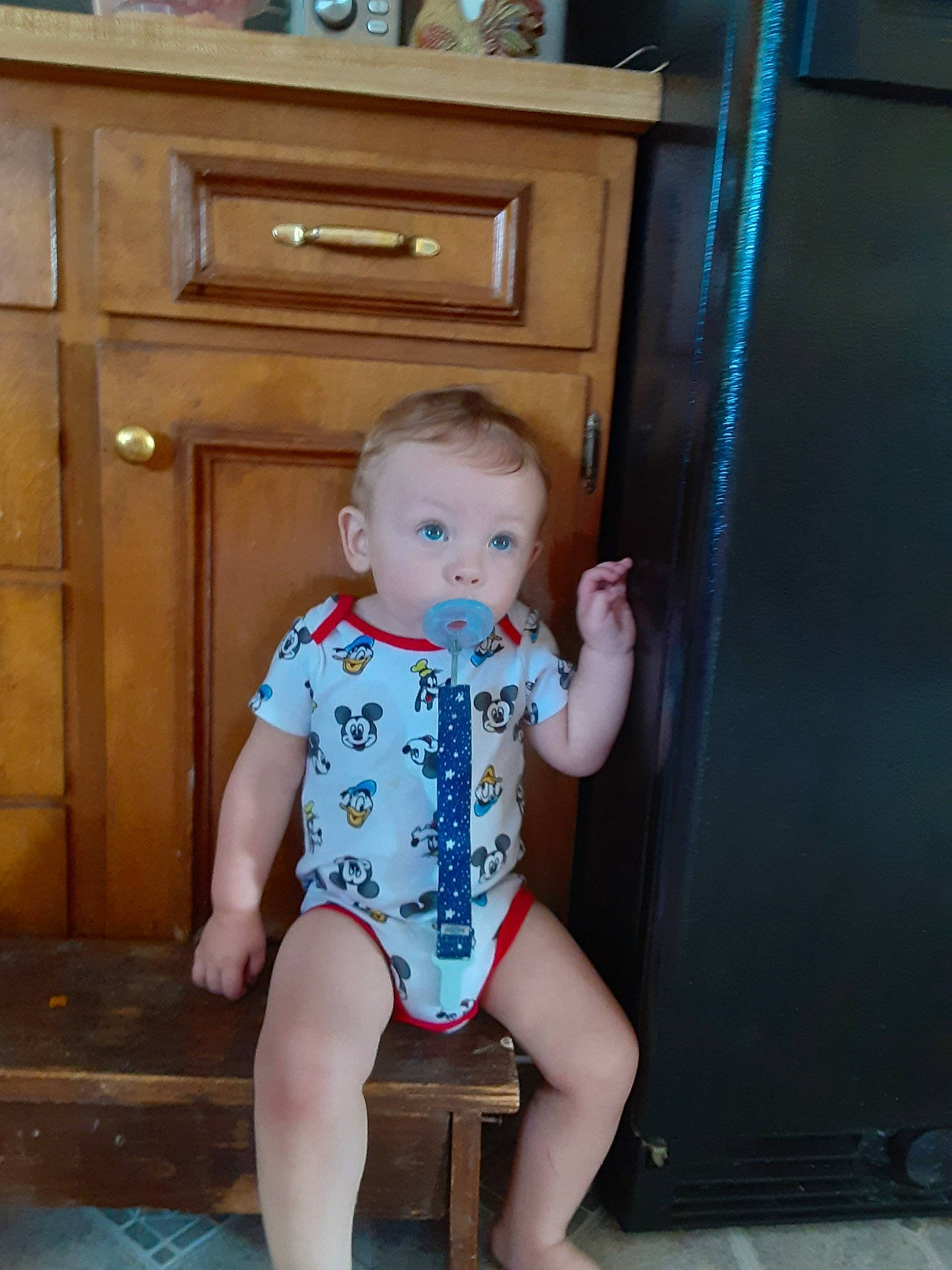 Paxton is registered to the contest to win money with this photo: baby, baby_toddler_clothing, cabinetry, chair, chest_of_drawers, drawer, dresser, electric_blue, flooring, hardwood, human_leg, knee, person, sleeve, standing, surprise, thigh, toddler, trunk, varnish