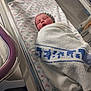 Arabella is registered to the contest to win money with this photo: newborn, baby, hospital, blanket, bassinet, infant, sleeping, wrapped, knitted_cap, linens, medical_equipment, bed, patient, child, cute, resting, healthcare, soft, towel, person