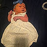 Scarlett is registered to the contest to win money with this photo: baby, infant, dress, headband, blue_bow, white_dress, anchor_pattern, socks, lying_down, curious_expression, newborn, child, portrait, indoor, soft_lighting, fabric, cute, small_hands, baby_fashion, background
