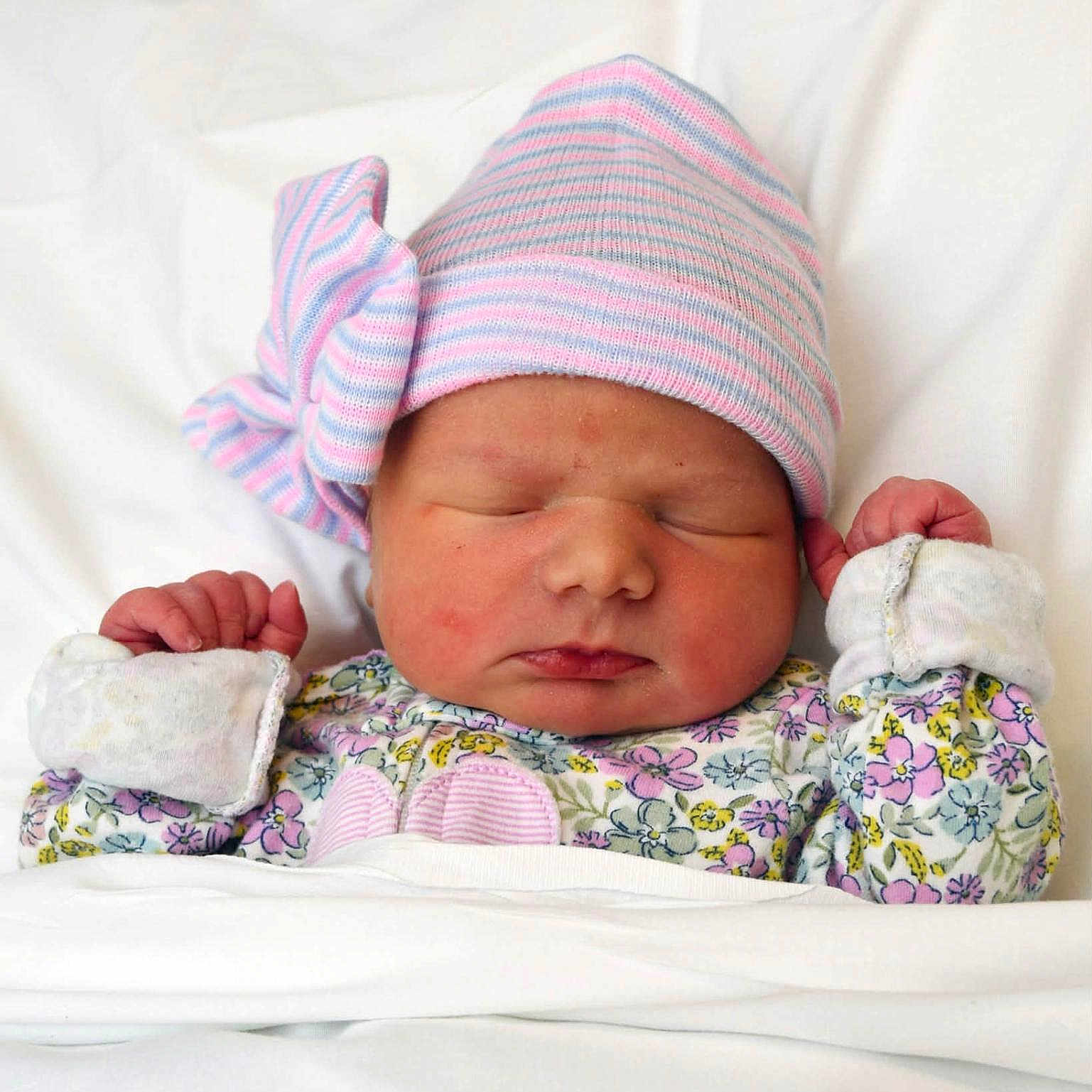 Scarlett is registered to the contest to win money with this photo: newborn, baby, sleeping, hat, striped_hat, bow, floral_onesie, blanket, white_background, infant, cute, peaceful, cozy, child, portrait, indoors, soft_lighting, small_hands, resting, wearing_clothes