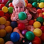 Bethany joined the competition — help win amazing prizes! baby, child, ball_pit, colorful_balls, headband, white_flower, pink_clothing, tattooed_hand, playtime, indoor, toy, cute, infant, footwear, black_shoe, smiling, happy, person, holding_ball, fun