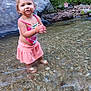 Juliet is registered to the contest to win money with this photo: toddler, child, water, stream, nature, rocks, greenery, outdoor, skirt, top, standing, messy_face, shallow_water, curious, playful, person, daylight, summer, hair_tied, barefoot