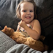 Amara joined the competition — help win amazing prizes! animal, blanket, cat, child, clothing, couch, cozy, cute, face, friendship, hair, happy, home, indoor, orange_cat, pet, relaxing, smile, texture, toddler