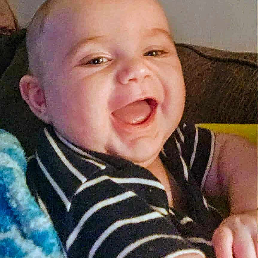 Johnny joined the competition — help win amazing prizes! arm, baby, baby_clothes, blanket, cheerful, child, couch, cute, face, happy, head, indoor, infant, mouth_open, person, portrait, skin, smiling, striped_shirt, young_child