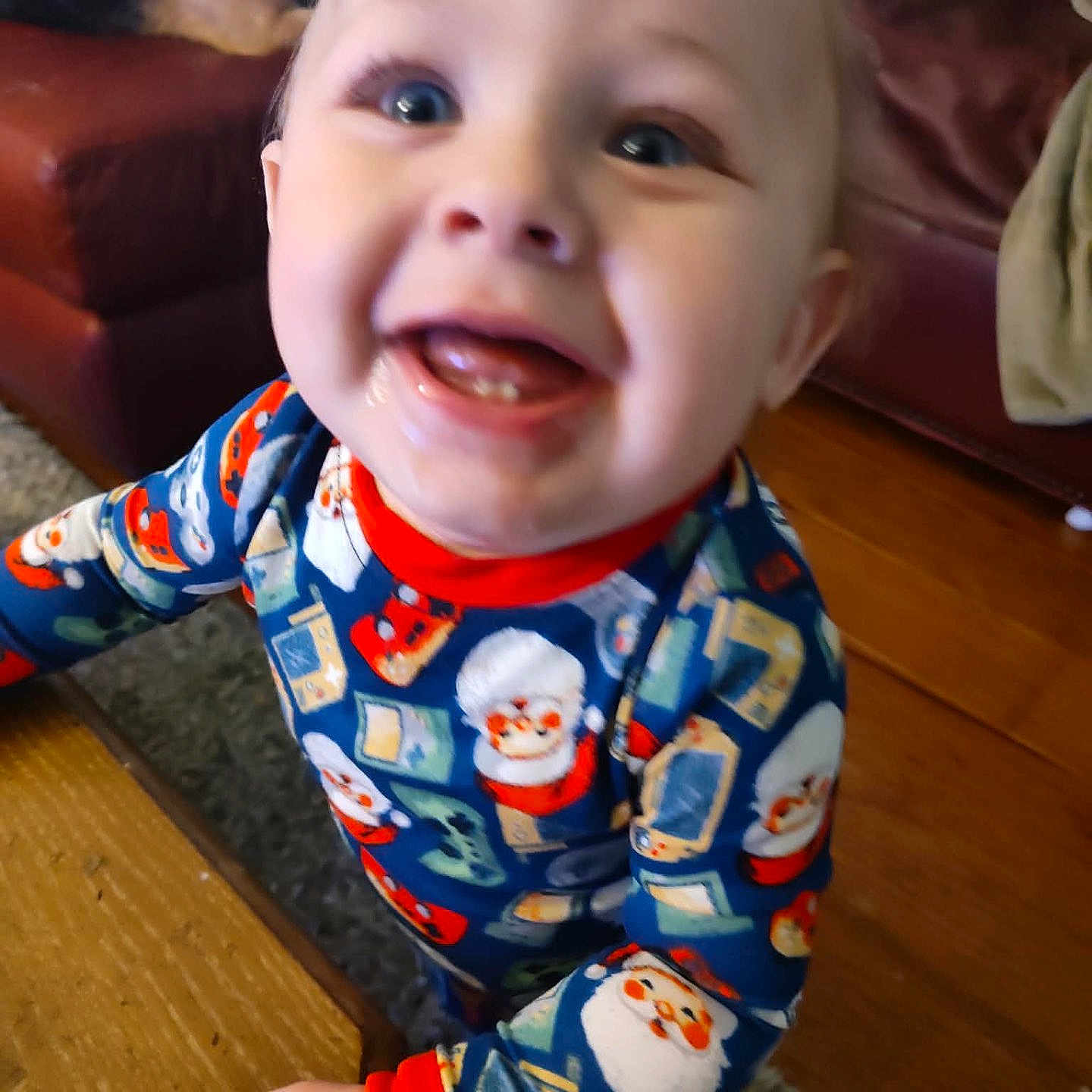 Jacob is registered to the contest to win money with this photo: toddler, child, smile, pajamas, santa_claus, holiday, indoor, happy, face, person, wooden_floor, couch, carpet, hand, clothing, baby, home, cute, cheerful, playful