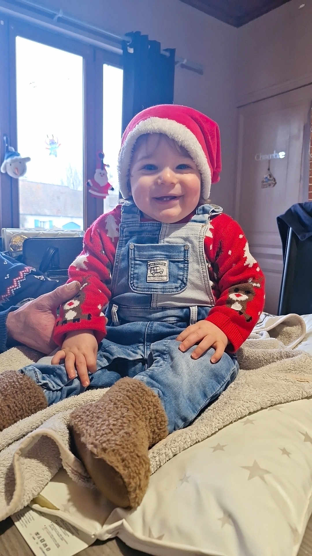 Maëvan participe au concours pour gagner de l'argent avec cette photo : baby, bodypart, bonnet, cap, clothing, coat, couch, face, finger, furniture, hand, hat, head, jacket, jeans, pants, person, photography, portrait, sitting
