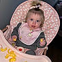 toddler, child, high_chair, snacks, bib, pink, hair_bow, polka_dot, face, eating, food, indoor, cute, baby, clothing, feeding, seat, happy, messy, portrait