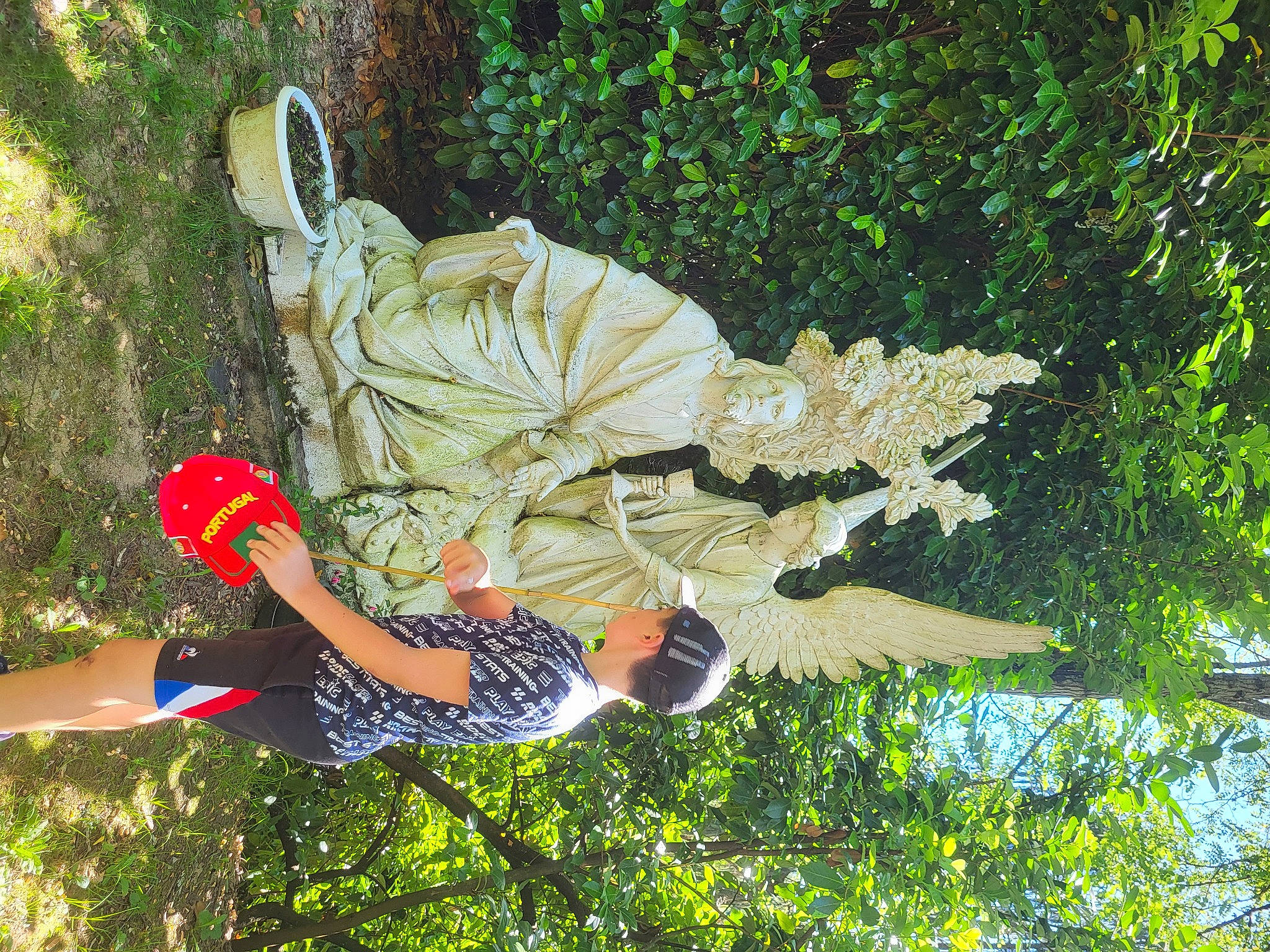 Erwan participe au concours pour gagner de l'argent avec cette photo : art, fun, garden, grass, happy, jungle, lawn_ornament, leisure, organism, people_in_nature, person, plant, recreation, sculpture, shorts, shrub, sitting, statue, tail, tree