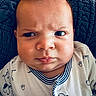 Hunter joined the competition — help win amazing prizes! baby, face, expression, furrowed_brow, intense_gaze, infant, clothing, dog_pattern, onesie, blue_blanket, portrait, closeup, skin, head, cheeks, eyes, person, indoors, cute, serious_expression