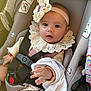 Isabella joined the competition — help win amazing prizes! baby, infant, car_seat, headband, lace_collar, clothing, seatbelt, child, cute, hand, face, sitting, indoors, person, safety, adorable, expression, soft_lighting, closeup, portrait