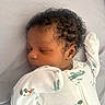 Jacari is registered to the contest to win money with this photo: baby, sleeping, infant, onesie, curly_hair, bed, sleep, cozy, child, cute, peaceful, soft_light, dinosaur_print, newborn, portrait, resting, person, closeup, indoor, young