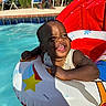 toddler, child, pool, water, inflatable_ring, smile, sunlight, shadow, summer, outdoor, fun, happy, toy, disney, swimming, baby, playful, vacation, relaxation, floating