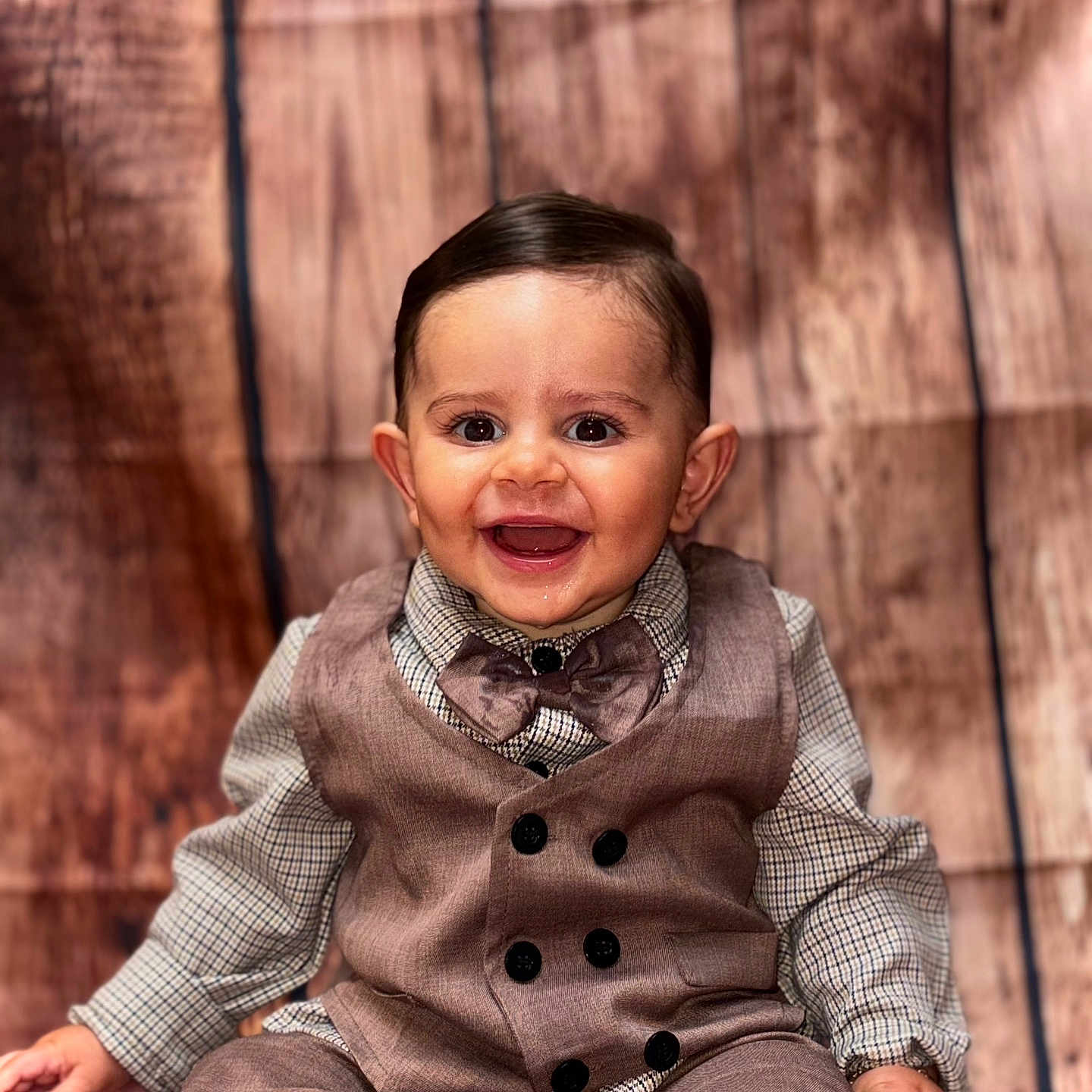 Benjamin a rejoint le concours — aidez-le/la à gagner de superbes lots ! baby, bow_tie, boy, button_up_shirt, child, cute, eyes, face, fashion, formal_wear, hair, hands, happy, indoor, portrait, sitting, smiling, vest, wooden_background, young_child
