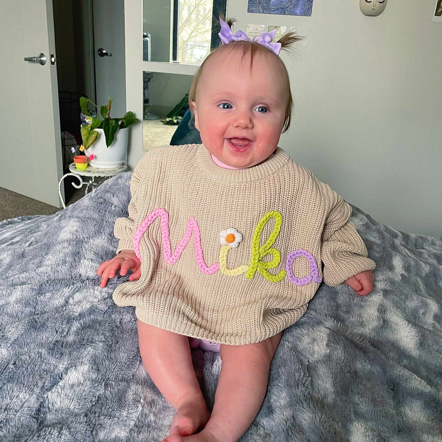 Mika is registered to the contest to win money with this photo: baby, bed, bedroom, bodypart, clothing, cup, dress, face, finger, furniture, hand, happy, head, indoors, knitwear, person, photography, portrait, sitting, sweater