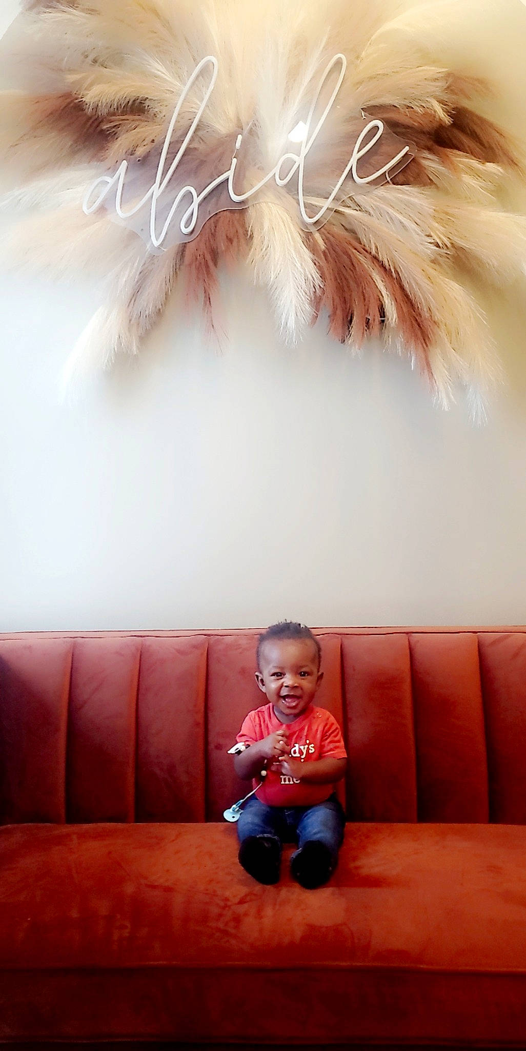 Ezra is registered to the contest to win money with this photo: baby, baby_toddler_clothing, comfort, couch, event, feather, flooring, hairstyle, happy, light, lighting, magenta, person, photograph, pink, room, smile, snapshot, toddler, white