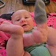 Kelly is registered to the contest to win money with this photo: baby, infant, child, sock, foot, blanket, indoor, floor, toy, walker, happy, smiling, clothing, cute, skin, person, playful, lying_down, home, cozy