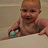 Kelly is registered to the contest to win money with this photo: baby, child, infant, smiling, face, eyes, curly_hair, bath, bathtub, bathroom, bath_toy, water, sitting, portrait, indoor, candid, happy, bare_shoulders, parenting, home