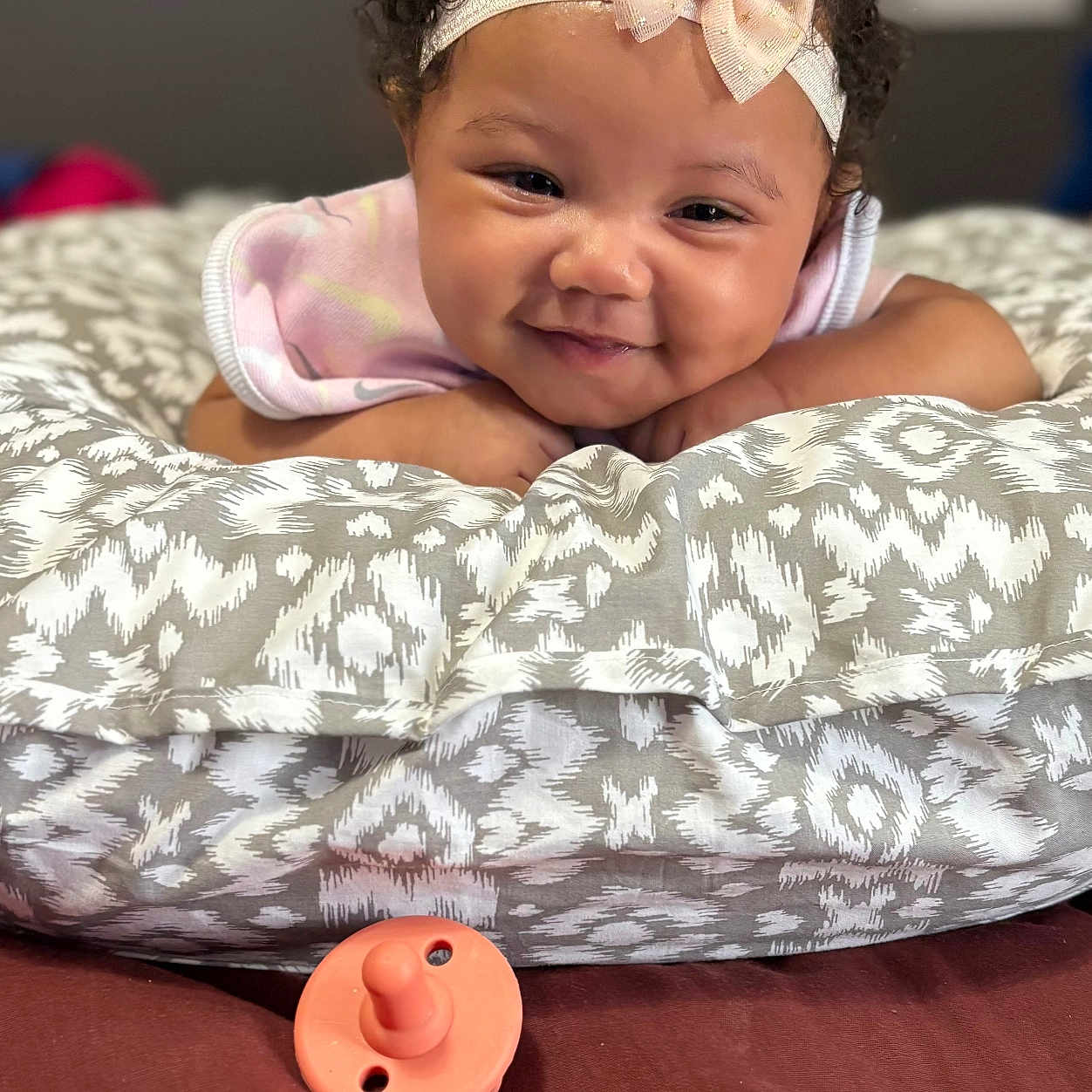 Kvori joined the competition — help win amazing prizes! baby, baby_girl, child, closeup, cozy, curly_hair, cushion, cute, expression, face, happy, headband, indoor, infant, lying_down, pacifier, patterned_fabric, portrait, smiling, soft_lighting