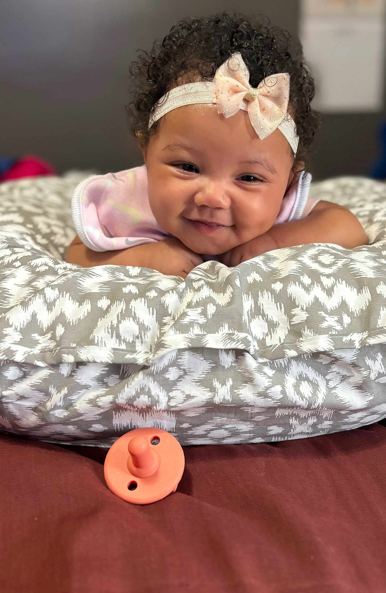 Kvori joined the competition — help win amazing prizes! baby, baby_girl, child, closeup, cozy, curly_hair, cushion, cute, expression, face, happy, headband, indoor, infant, lying_down, pacifier, patterned_fabric, portrait, smiling, soft_lighting