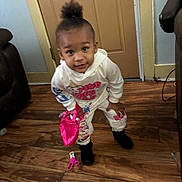 Kennedy joined the competition — help win amazing prizes! black_boots, casual_clothing, child, curious, curly_hair, cute, door, flooring, home, indoor, person, pink_bag, playful, room, standing, toddler, toy, white_outfit, wooden_floor, young_child