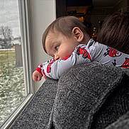 Cameron is registered to the contest to win money with this photo: adult, car_pattern, child, clothing, cozy, face, gazing, gray, home, indoor, pajamas, person, portrait, reflection, shoulder, snow, thoughtful, toddler, window, winter