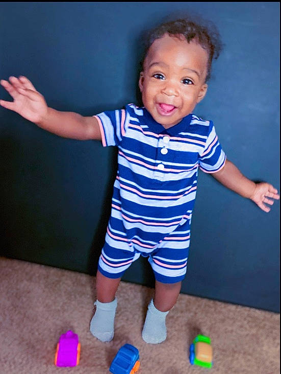 Jakobe is registered to the contest to win money with this photo: arm, baby, baby_products, baby_toddler_clothing, child, person, play, product, shoe, sleeve, smile, standing, t_shirt, toddler