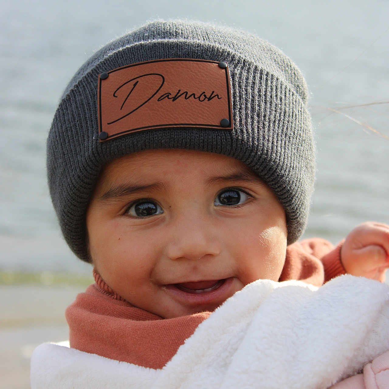 Damon is registered to the contest to win money with this photo: baby, beanie, bodypart, bonnet, cap, clothing, face, finger, fleece, hand, happy, hat, head, hood, hoodie, knitwear, person, smile, sweater, sweatshirt