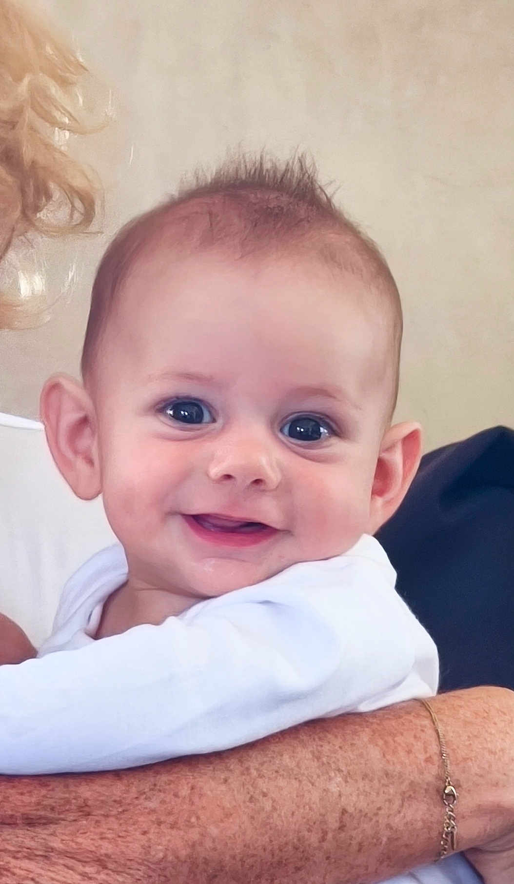 Léo participe au concours pour gagner de l'argent avec cette photo : baby, smiling, face, person, child, white_clothing, arm, bracelet, freckles, hair, skin, portrait, happy, cute, infant, holding, closeup, expression, eyes, background