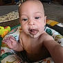 Omari is registered to the contest to win money with this photo: baby, child, drool, face, hand, indoor, toy, colorful, seat, carpet, living_room, person, skin, expression, curious, young_child, infant, playtime, furniture, closeup