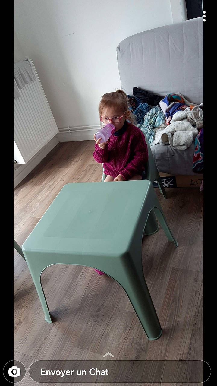 Anya participe au concours pour gagner de l'argent avec cette photo : baby_toddler_clothing, chair, child, comfort, floor, flooring, furniture, hardwood, human_body, leisure, magenta, outdoor_furniture, person, rectangle, room, sitting, sleeve, t_shirt, table, toddler