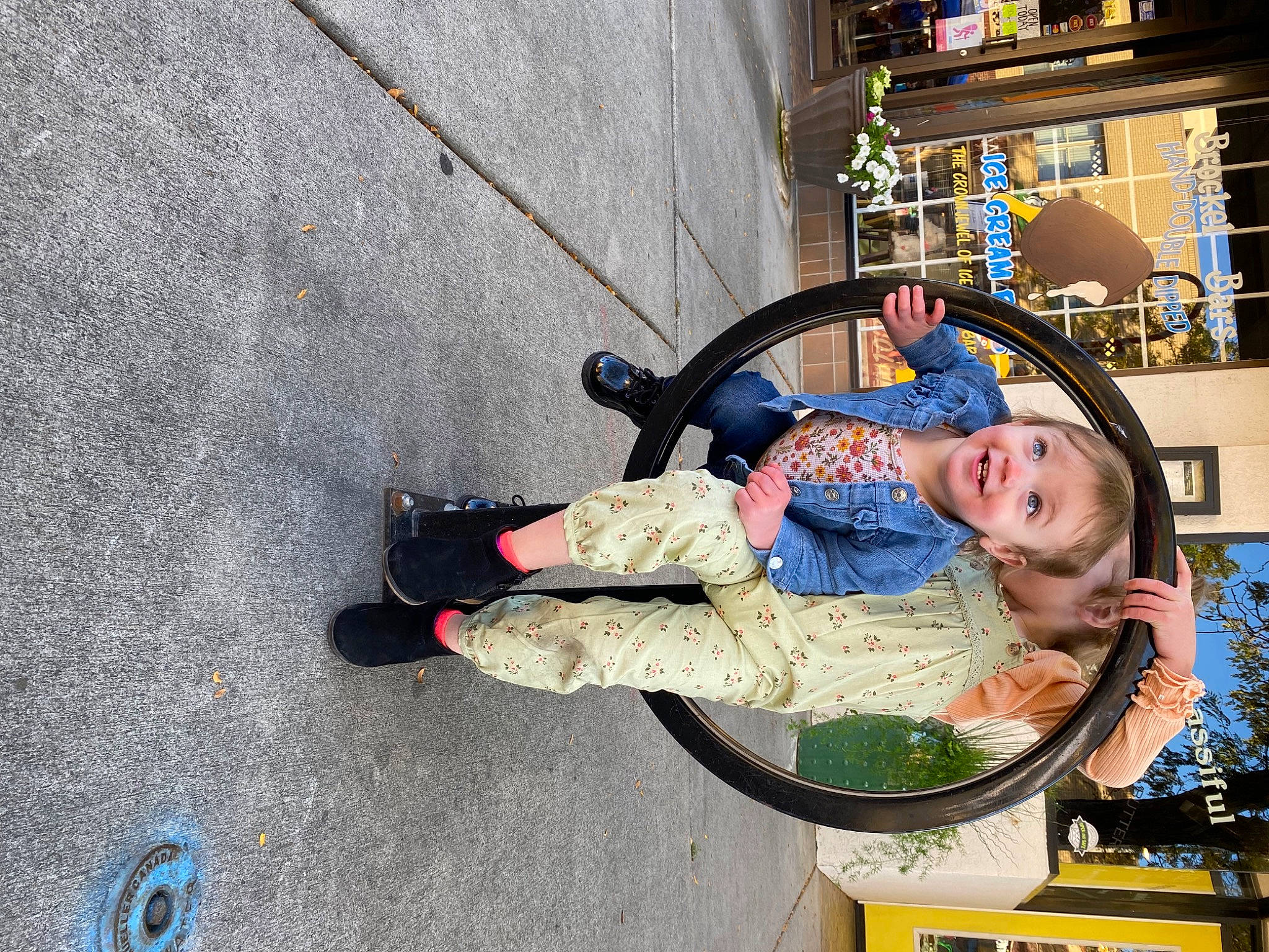 Pepper is registered to the contest to win money with this photo: asphalt, child, city, concrete, eyewear, fun, joy, leisure, pedestrian, person, plant, recreation, road_surface, sidewalk, sitting, street, tire, toddler, travel, tree