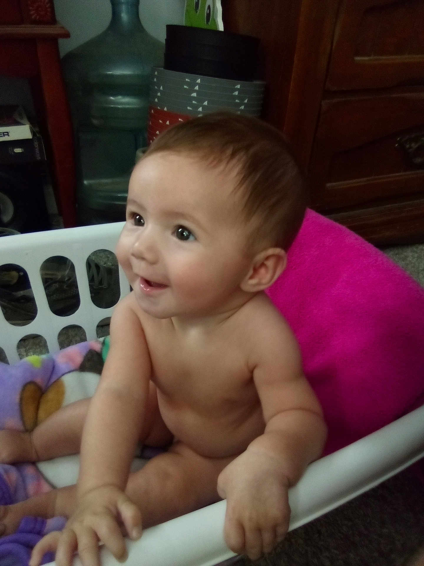 Clementine joined the competition — help win amazing prizes! baby, child, laundry_basket, blanket, indoor, smiling, cute, skin, hand, face, curious, sitting, furniture, wood, floor, home, young, infant, expression, room