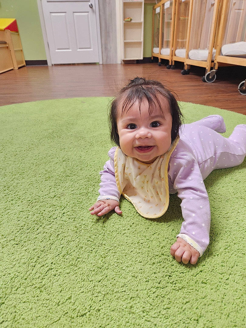 Allyson is registered to the contest to win money with this photo: baby, baby_toddler_clothing, cabinetry, cheek, comfort, crawling, door, floor, flooring, fun, grass, green, happy, hardwood, joy, person, room, skin, smile, toddler