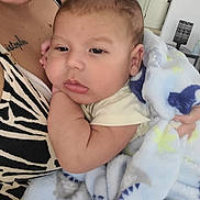 Gael Francisco Campo is registered to the contest to win money with this photo: baby, blanket, arm, person, face, skin, clothing, hand, indoor, comfort, child, infant, holding, zebra_print, tattoo, peaceful, soft, cute, portrait, sleepy