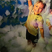 Amir participe au concours pour gagner de l'argent avec cette photo : child, foam, bubbles, smiling, happy, party, play, fun, wet, boy, shorts, tshirt, foam_party, celebration, outdoor, people, night, colorful, joy, hands_up