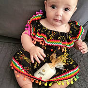 Lina a rejoint le concours — aidez-le/la à gagner de superbes lots ! baby, infant, dress, colorful_clothing, pom_poms, candle, wrapped_gift, sitting, gray_background, cute, child, portrait, indoors, jewelry, necklace, footwearless, hand, face, eyes, soft_surface