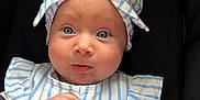 Delilah is registered to the contest to win money with this photo: adorable, baby, blue_eyes, bow, child, closeup, clothing, curious_expression, cute, fashion, hands, headband, indoor, infant, person, portrait, sitting, soft_skin, striped_clothing, young_child