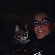 Hopper Jean Mcmahan joined the competition — help win amazing prizes! person, cat, glasses, smile, dark, night, indoor, cozy, tabby_cat, face, portrait, animal, pet, clothing, jacket, closeup, human, comfort, friendship, warmth