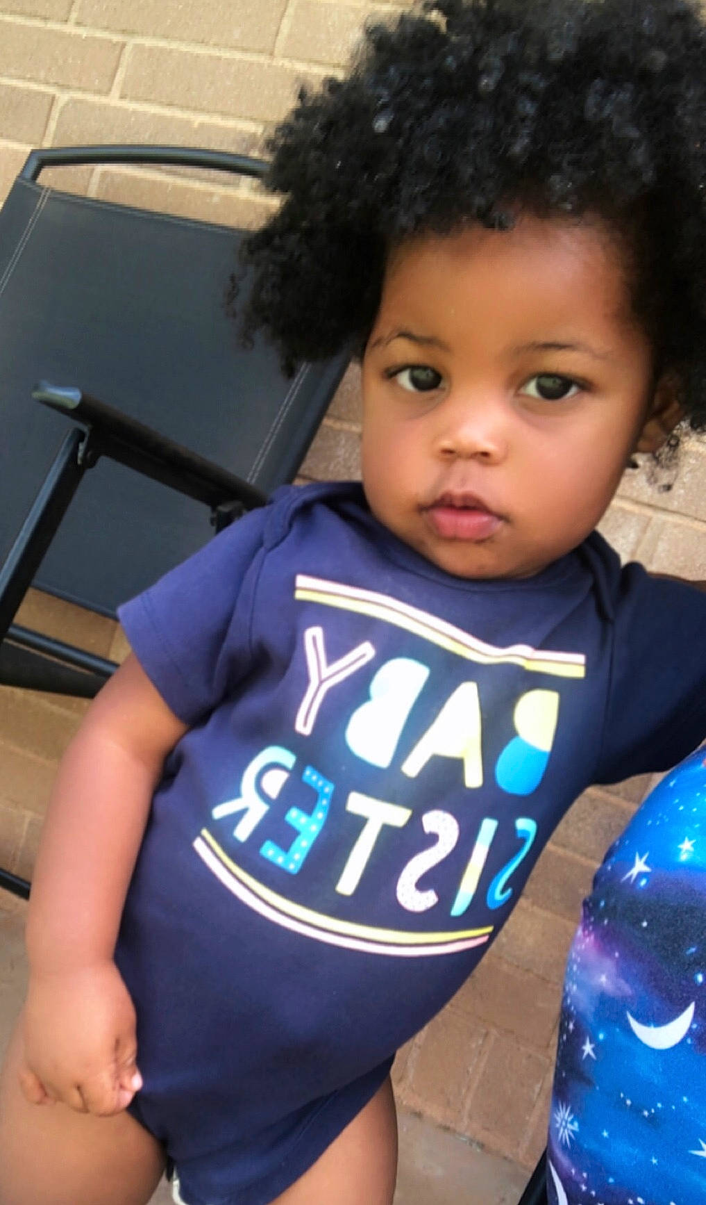 Kamiyah is registered to the contest to win money with this photo: afro, black_hair, chest, child, cool, electric_blue, fun, grass, happy, human_leg, leisure, neck, nose, person, sitting, sleeve, sportswear, t_shirt, thigh, toddler