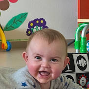 Kassïm participe au concours pour gagner de l'argent avec cette photo : baby, smiling, tummy, toy, colorful, indoor, child, face, happy, cute, play, infant, clothing, pattern, star, wall_art, floor, expression, person, young