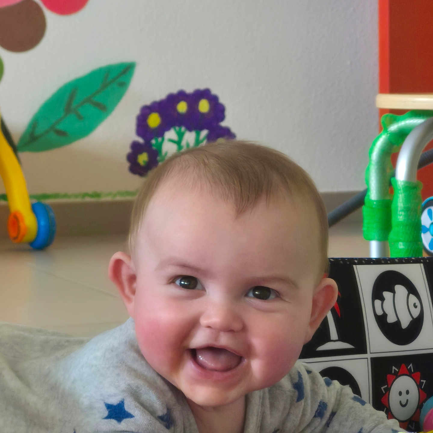 Kassïm participe au concours pour gagner de l'argent avec cette photo : baby, smiling, tummy, toy, colorful, indoor, child, face, happy, cute, play, infant, clothing, pattern, star, wall_art, floor, expression, person, young