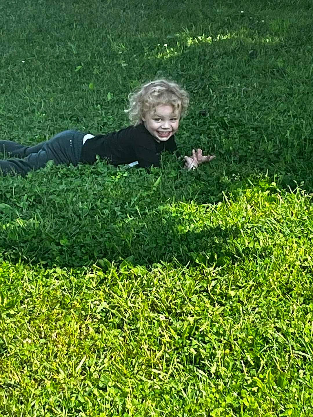 Chase is registered to the contest to win money with this photo: artificial_turf, flooring, garden, grass, grass_family, grassland, groundcover, happy, joy, lawn, meadow, pasture, people_in_nature, person, plant, prairie, shrub, sitting, smile, terrestrial_plant